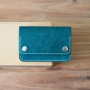 Noir & Co. Hercules Trucker Wallet Deri Petrol - Chestnut Hakiki Puablo kapalı hali, pirinç çıt detayı görünümü